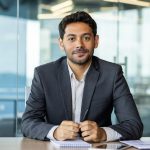 Portrait of a young investor banker at the workplace inside the bank office, a businessman in a